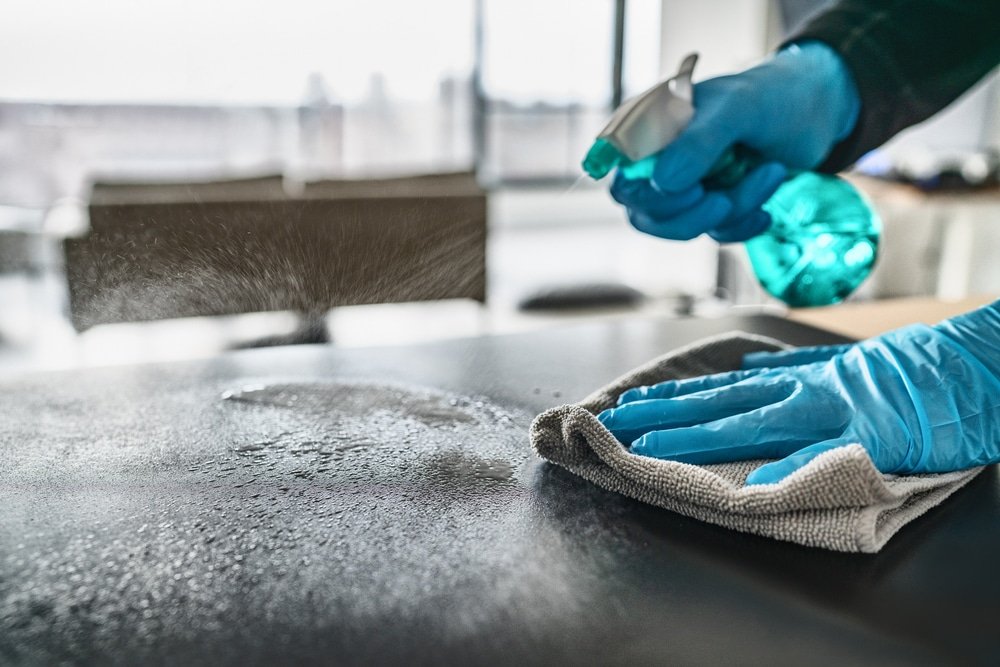 Des mains nettoient une surface avec un chiffon